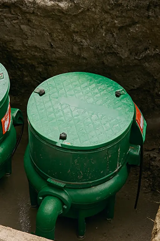 installation de pompe relevage autour de marignane Deux réservoirs verts enterrés dans le sol.