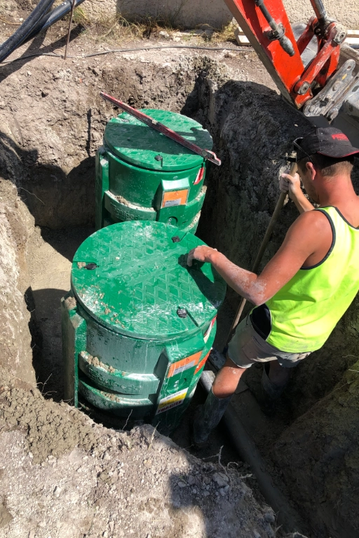 Installation de cuves vertes par un ouvrier.