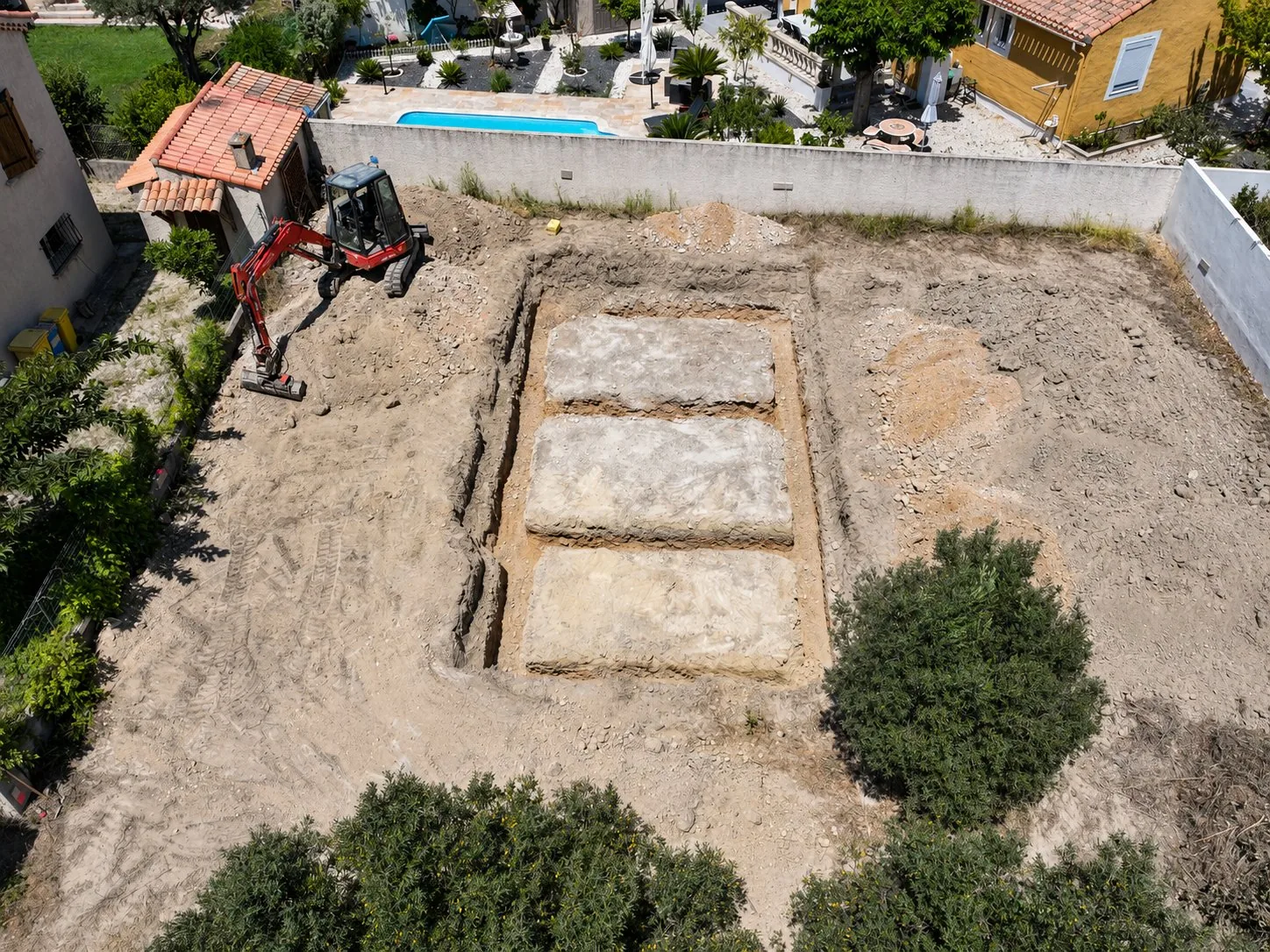 Chantier d’excavation avec pelleteuse et dalles enterrées