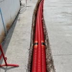 Tranchée avec gaines rouges sur chantier