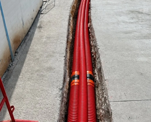 Tranchée avec gaines rouges sur chantier