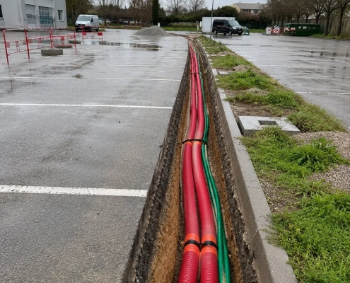 Tranchée avec gaines rouges et vertes parking